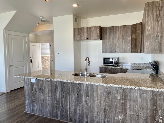 22 E Cedar Ln, Malad City, ID 83252 - kitchen with dark wood-type flooring, kitchen peninsula, light stone countertops, stainless steel appliances, and sink
