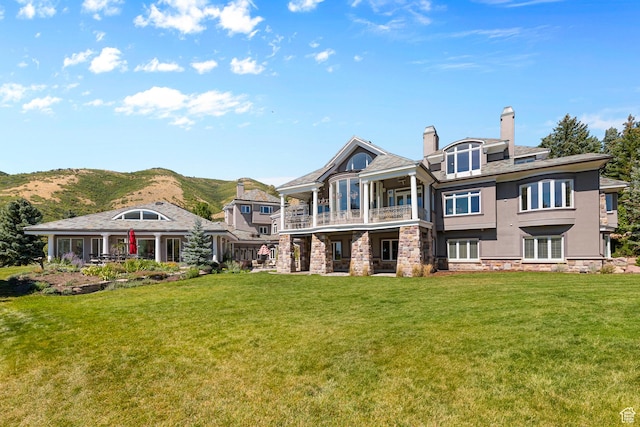 5678 E Twin Creek Rd, Emigration Canyon, UT 84108 - back of property featuring a balcony, a chimney, a yard, a mountain view, and stucco siding