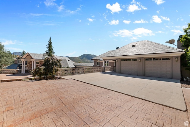 5678 E Twin Creek Rd, Emigration Canyon, UT 84108 - view of front of home featuring concrete driveway, a mountain view, a garage, and fence