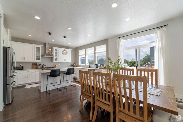 dining room featuring a textured ceiling, dark wood-style floors, and recessed lighting