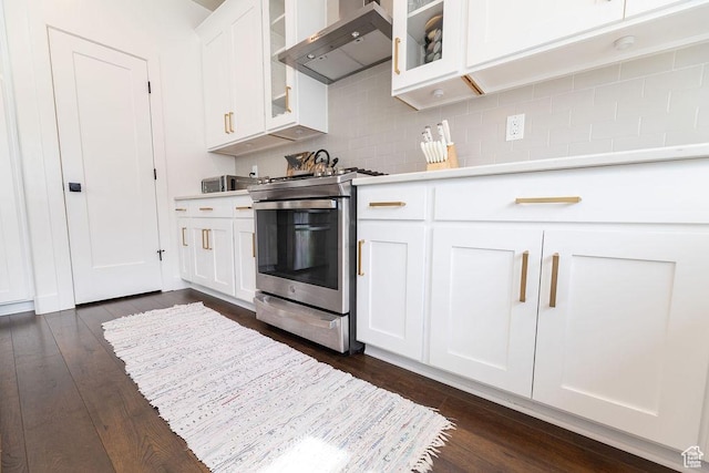 kitchen with wall chimney exhaust hood, stainless steel electric stove, light countertops, and dark wood-style flooring