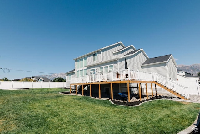 back of property with a yard, stairway, fence, and a wooden deck