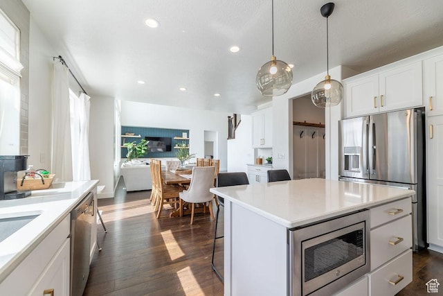 kitchen with dark wood-style floors, white cabinetry, light countertops, and stainless steel appliances