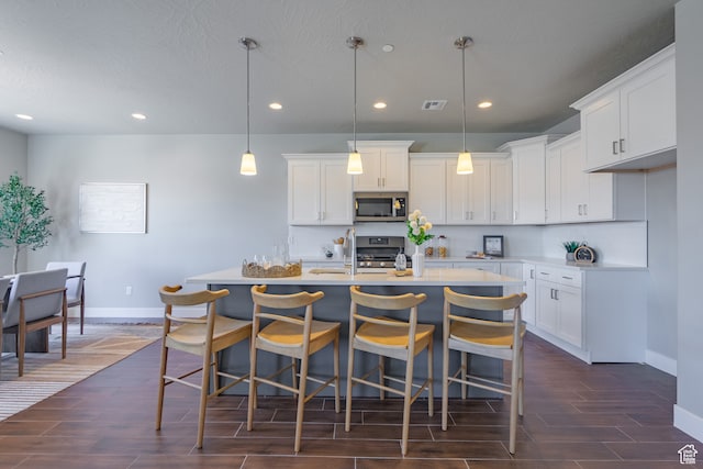278 N 2020 W, Hurricane, UT 84737 - kitchen with a center island with sink, white cabinetry, stainless steel appliances, and dark hardwood / wood-style flooring