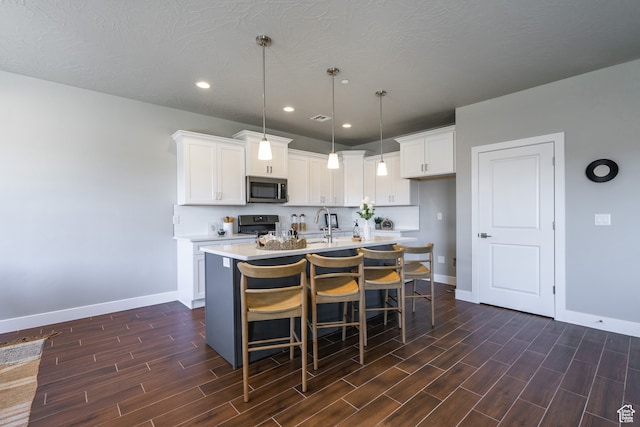 278 N 2020 W, Hurricane, UT 84737 - kitchen featuring white cabinets, a kitchen island with sink, and dark hardwood / wood-style flooring