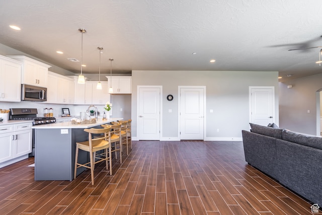 278 N 2020 W, Hurricane, UT 84737 - kitchen featuring appliances with stainless steel finishes, dark hardwood / wood-style floors, and a kitchen island with sink