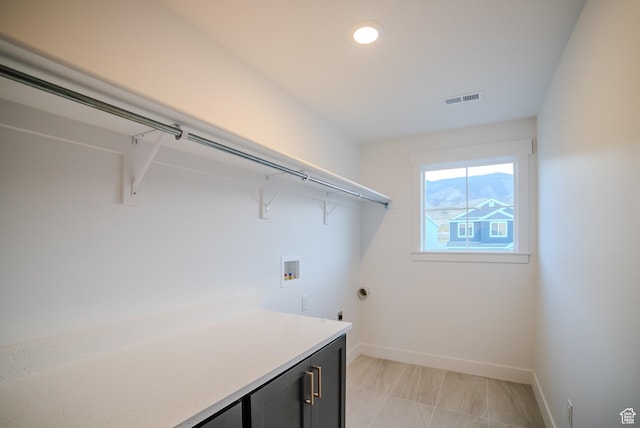 laundry area with baseboards, gas dryer hookup, visible vents, washer hookup, and cabinet space