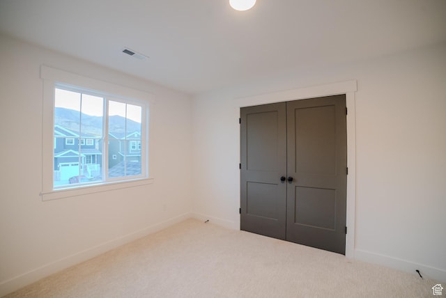 unfurnished bedroom featuring carpet floors, baseboards, and visible vents