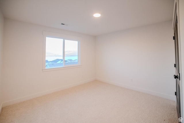 empty room with carpet flooring, baseboards, visible vents, and recessed lighting