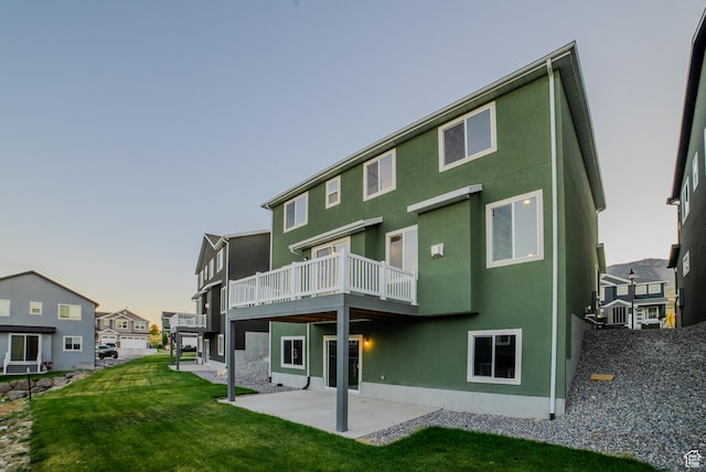 back of property with a deck, a residential view, a yard, a patio, and stucco siding