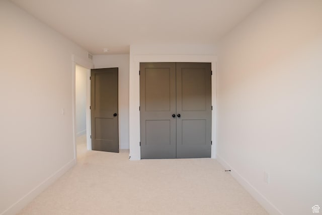 unfurnished bedroom featuring carpet flooring, a closet, and baseboards