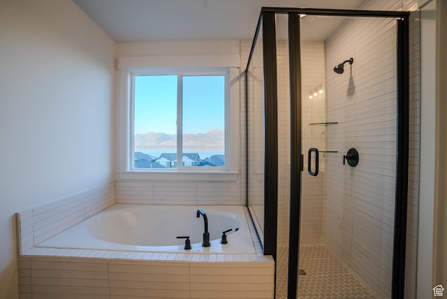 bathroom featuring a stall shower, a mountain view, and a bath