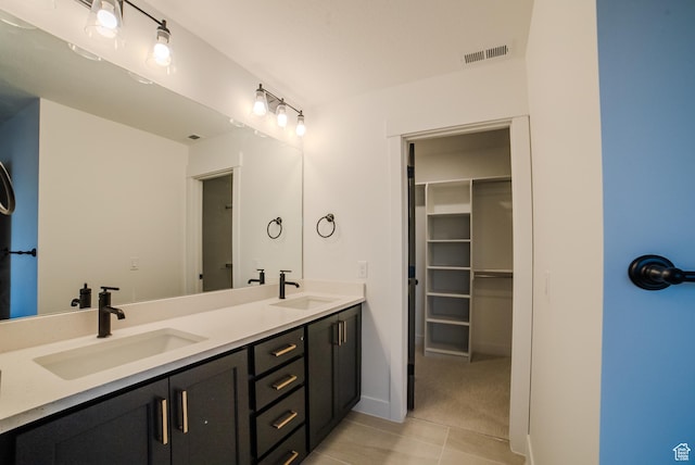 bathroom with double vanity, tile patterned floors, visible vents, and a sink