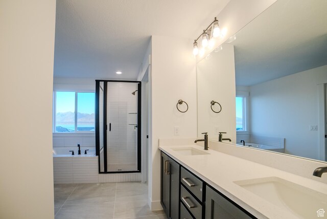full bathroom with a sink, double vanity, a shower stall, and a bath