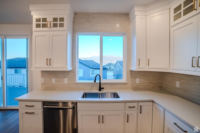 kitchen featuring white cabinetry, light countertops, a sink, and dishwasher