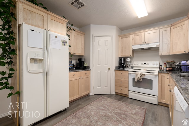 kitchen with light brown cabinetry, a textured ceiling, white appliances, and dark hardwood / wood-style flooring