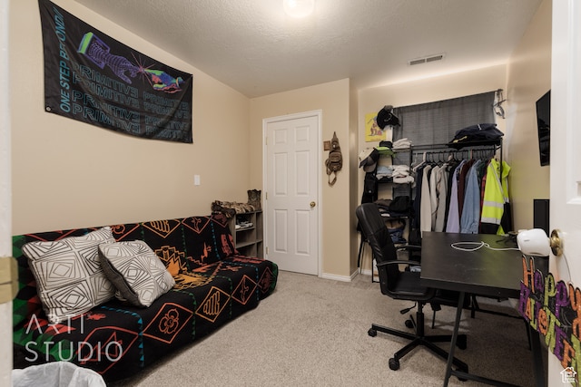 carpeted office featuring a textured ceiling