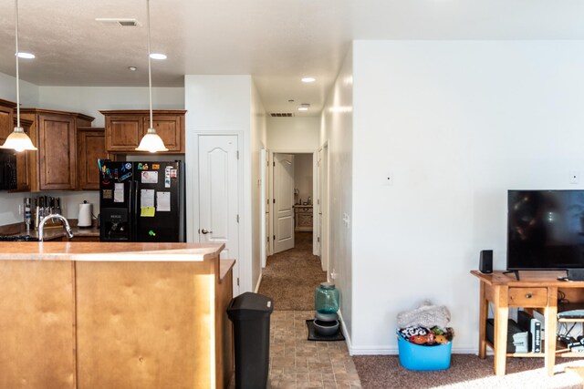 kitchen featuring visible vents, black appliances, and hanging light fixtures