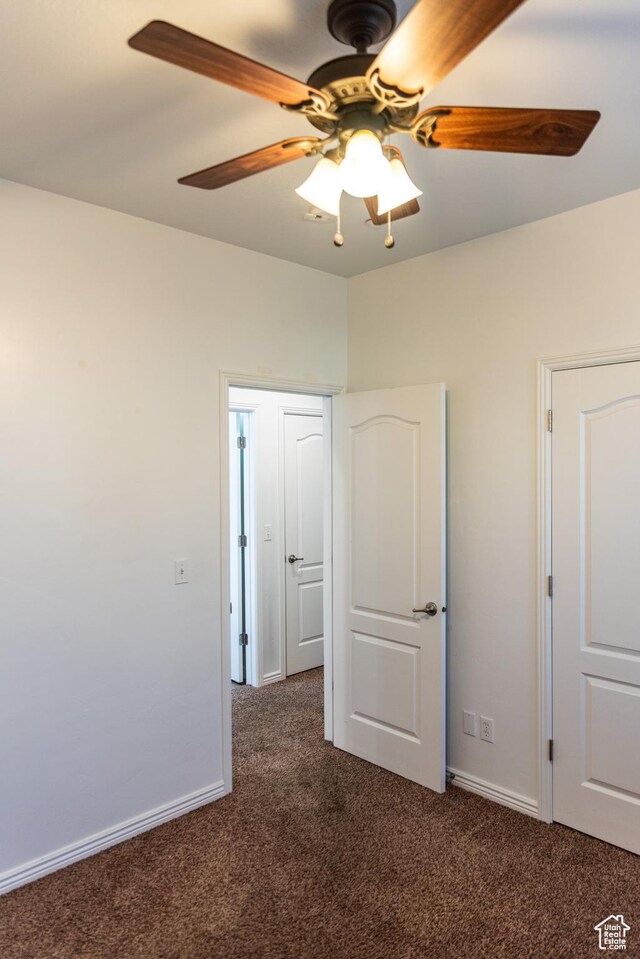 unfurnished bedroom with baseboards, carpet flooring, and a ceiling fan
