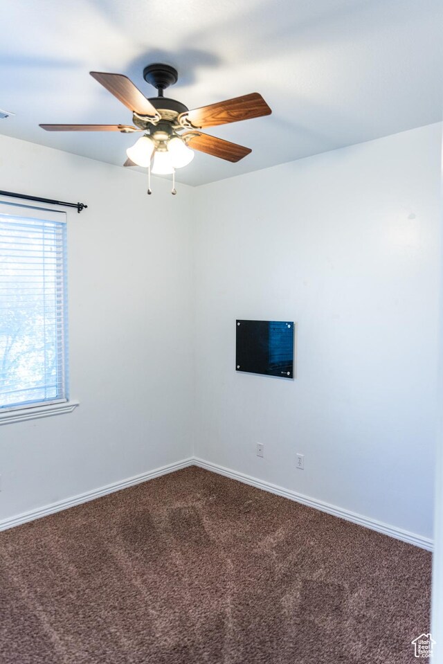 unfurnished room featuring carpet flooring, baseboards, and ceiling fan