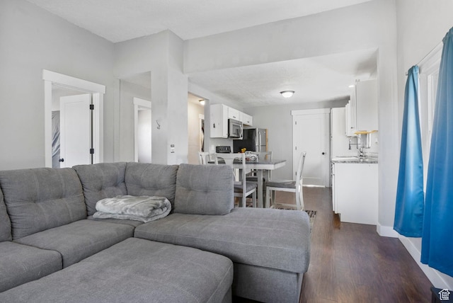 living room with baseboards and dark wood-type flooring