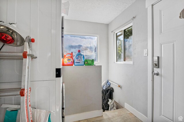 interior space with a textured ceiling and baseboards