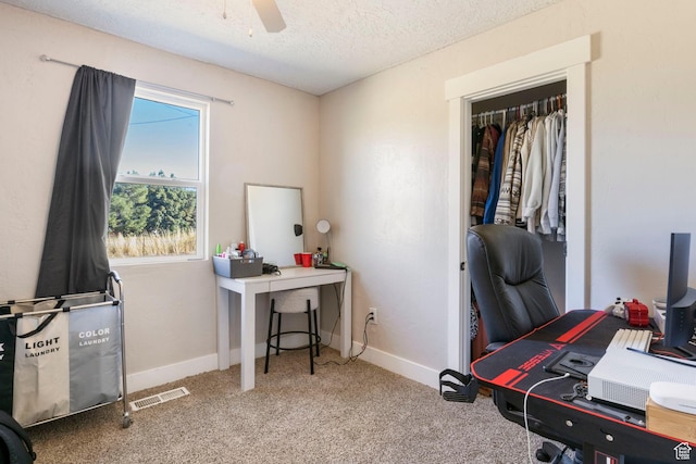 interior space featuring ceiling fan, visible vents, baseboards, a textured ceiling, and carpet floors