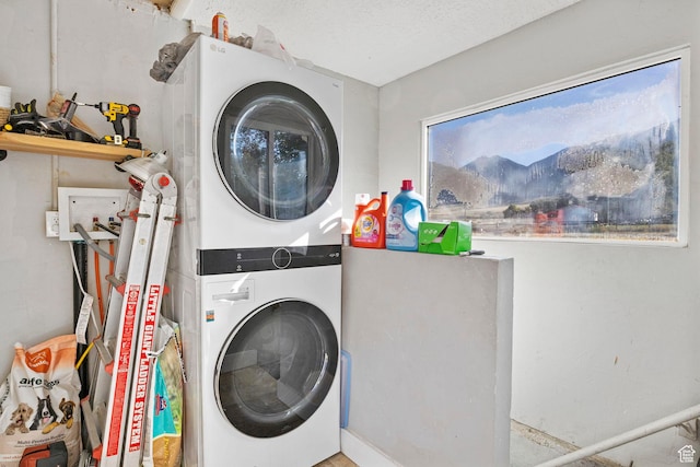 clothes washing area with stacked washer and dryer and laundry area