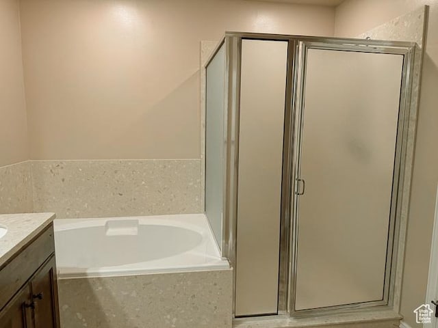 bathroom featuring vanity, a bath, and a stall shower