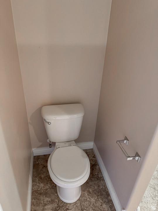 bathroom with baseboards and toilet