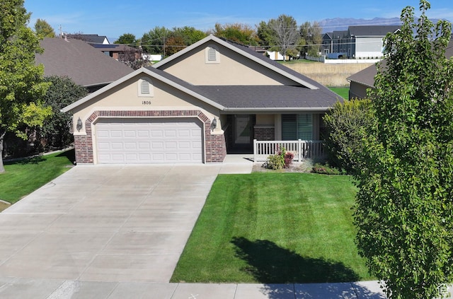 single story home with brick siding, an attached garage, a front yard, and concrete driveway