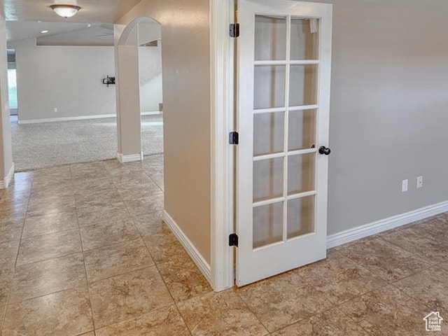 hallway featuring baseboards and tile patterned flooring