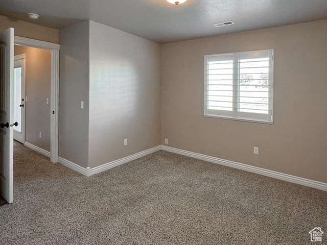 unfurnished room with baseboards, carpet, and visible vents