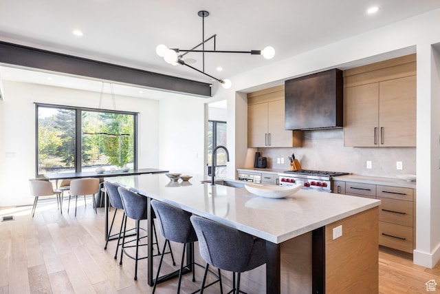 3576 Ridgeline Dr Unit 14-C, Park City, UT 84098 - kitchen featuring a sink, wall chimney range hood, range, tasteful backsplash, and light wood-style flooring