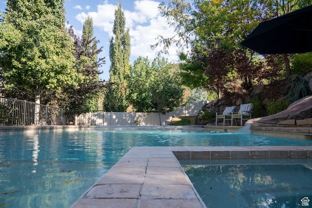 view of pool with a fenced in pool and fence