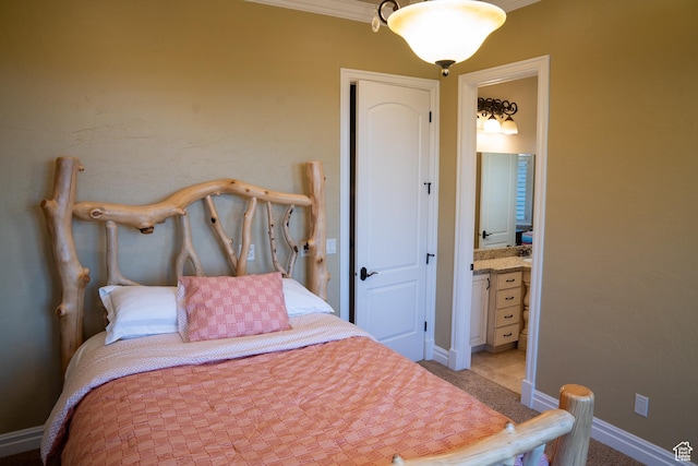 bedroom featuring light carpet, ensuite bathroom, baseboards, and crown molding