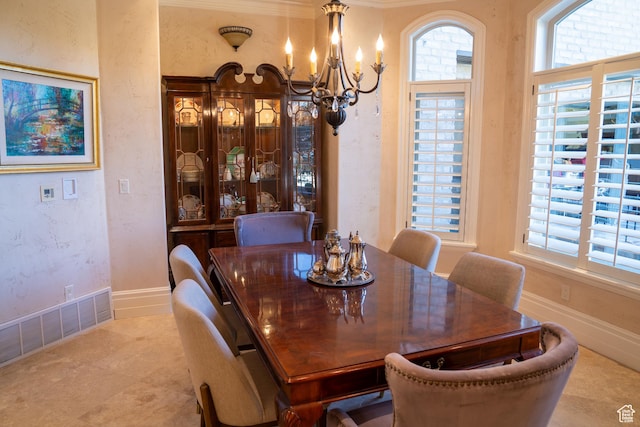 dining room featuring baseboards, a textured wall, a notable chandelier, and visible vents