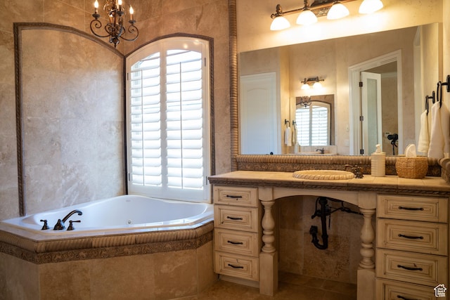 bathroom with a chandelier, a bath, vanity, and tile patterned flooring