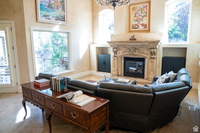 living area with visible vents, a premium fireplace, baseboards, and a healthy amount of sunlight