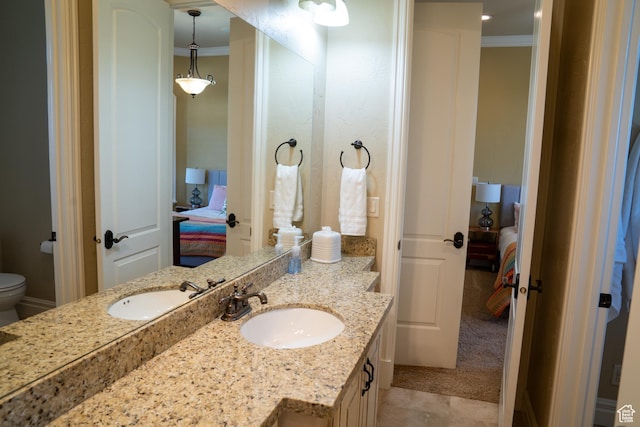 bathroom with ensuite bath, vanity, ornamental molding, and toilet
