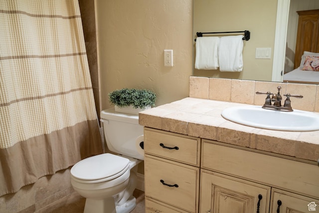 bathroom with curtained shower, vanity, and toilet