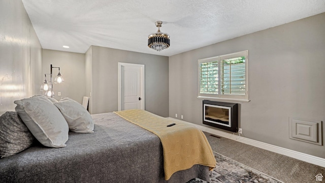 bedroom featuring baseboards, carpet flooring, visible vents, and a textured ceiling