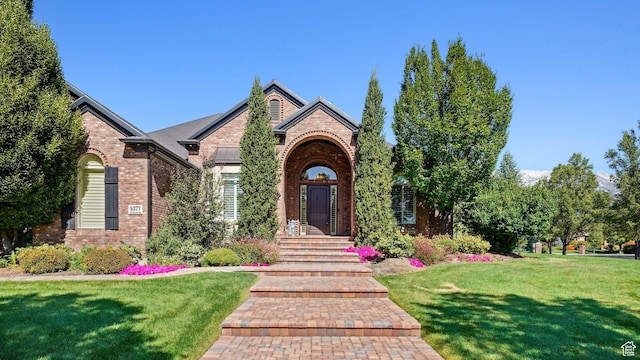 view of front of property with a front lawn and brick siding
