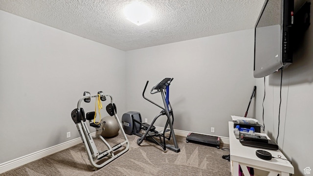 exercise area featuring a textured ceiling, carpet flooring, and baseboards