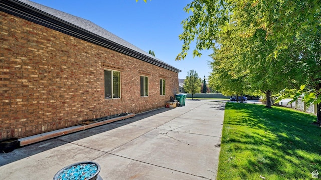 view of home's exterior featuring a yard, brick siding, and a patio area