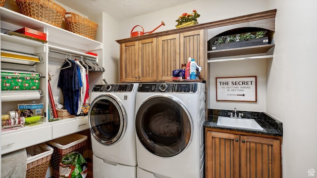 clothes washing area featuring washer and dryer, a sink, cabinet space, a textured ceiling, and wet bar