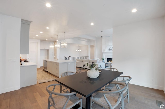 731 W Sara Dr, Saratoga Springs, UT 84045 - dining space with a lit fireplace, light wood-type flooring, baseboards, and recessed lighting