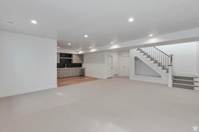 731 W Sara Dr, Saratoga Springs, UT 84045 - unfurnished living room with light carpet, stairs, baseboards, recessed lighting, and bar area