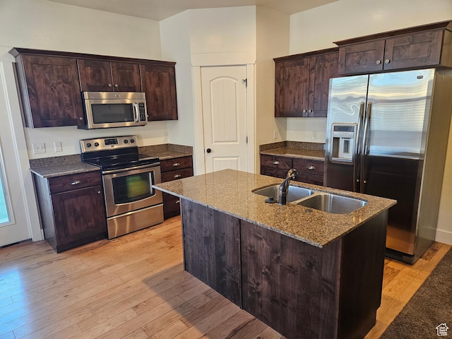 772 S 150 E, Smithfield, UT 84335 - kitchen with dark brown cabinetry, light wood-type flooring, dark stone counters, a sink, and stainless steel appliances