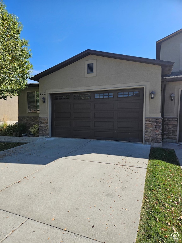 772 S 150 E, Smithfield, UT 84335 - exterior space featuring an attached garage, concrete driveway, stucco siding, and stone siding